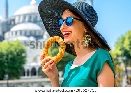 Young woman eating turkish bagel in Istanbul, Turkey. Traditional turkish street food.
