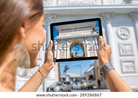 Woman photographing with digital tablet Macedonian gate in Skopje