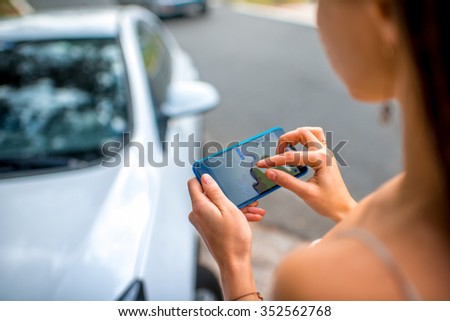 Woman using gps navigation on the smart phone near the car on the road