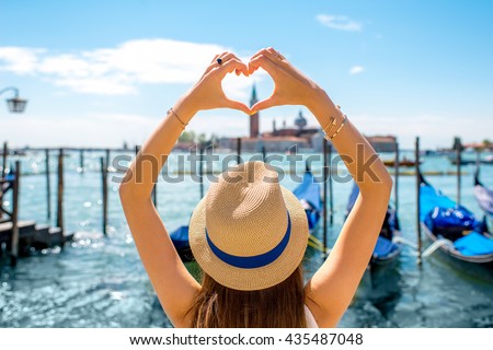Woman making heart shape with hands on the beautiful view in Venice. Venice is one of the favorite tourist city