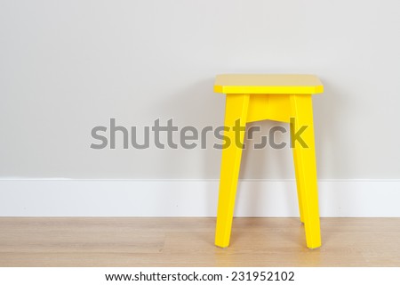 simple interior with a yellow stool and copy space on the wall