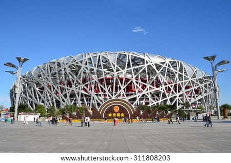 Beijing, China, October, 10, 2012. People walking near Bird\'s Nest in autumn day. The Bird\'s Nest is a stadium in Beijing, China, especially designed for use throughout the 2008 Summer Olympics games