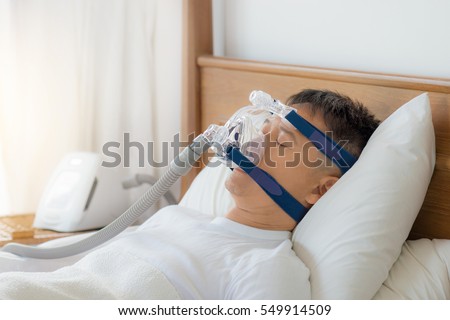 Obstructive sleep apnea therapy, Man wearing CPAP mask.\
CPAP:Continuous positive airway pressure  therapy.Happy and healthy senior man breathing more easily during sleep  on his back without snoring.