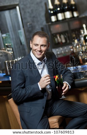 Yang business person relaxing with cocktail  in the hotel bar.