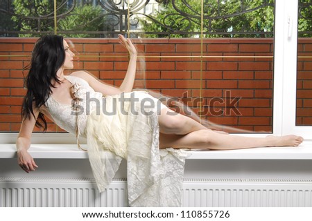 Portrait of yang and beautiful brunette in front of the window