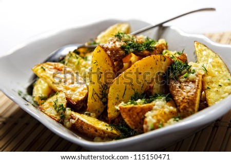Pieces of baked potatoes topped with cut dill.