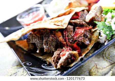 Arabic mixed barbeque plate with sauces and multiple garnish.