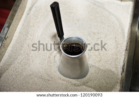 Picture of traditional Eastern coffee pot and sand box for its preparation.