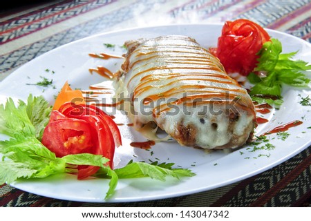 Plate of baked meat under white sauce