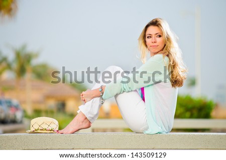 Yang pretty woman poses in stone bench in sunset time.