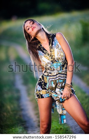 Yang and beautiful sexy woman poses outdoor countryside in sunset time.