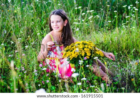 Portrait of school girl among the flowers in summer time.