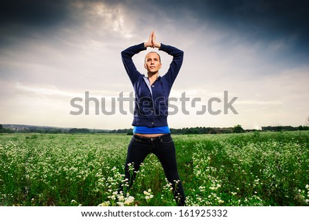 Young European woman performing yoga outdoor.
