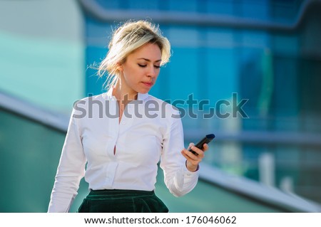 Yang and beautiful modern business woman poses outdoor with sell phone.