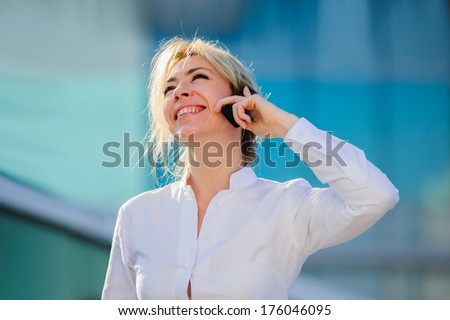 Yang and beautiful modern business woman poses outdoor with sell phone.