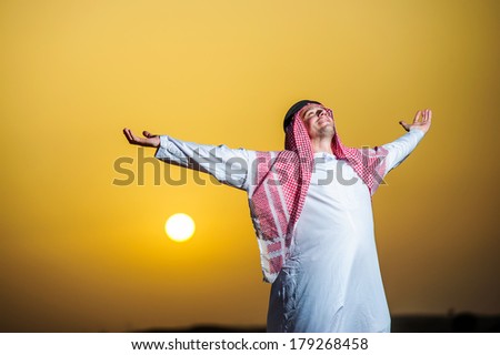Portrait of Middle Eastern Arab man in desert on sunset time.