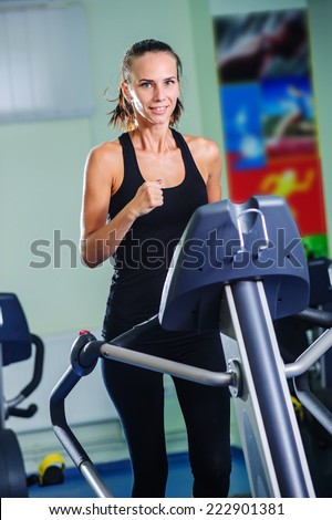 Yyoung woman runs on a treadmill, is engaged in fitness sport club .