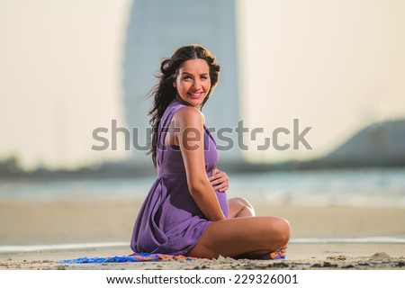 Yang and beautiful pregnant woman poses on the beach.