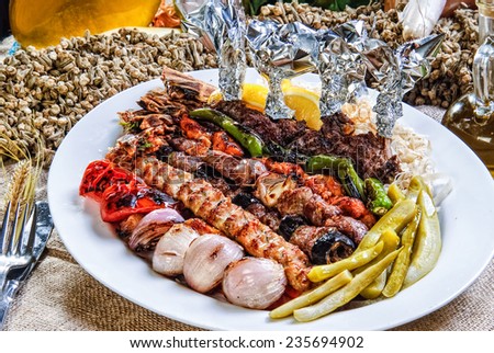 Plate of Arabic oriental barbeque, made of different kinds of meat,backed with vegetables.