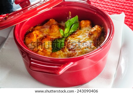 Italian lasagna plate served with fresh basil leaf.