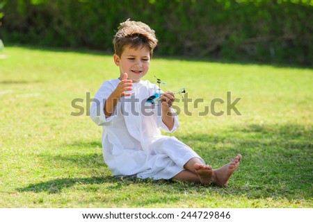 Arabic boy plays with toy helicopter.
