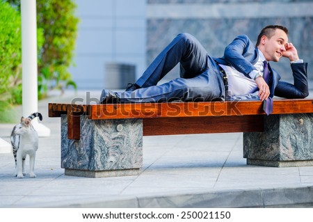 Yang businessman relaxing outdoors in the bench.
