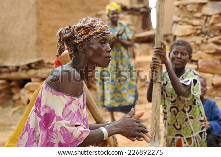 BANDIAGARA, MALI, AFRICA - AUGUST, 28, 2011 Dogon woman sings while other women grind millet