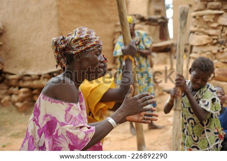 BANDIAGARA, MALI, AFRICA - AUGUST, 28, 2011 Dogon woman sings while other women grind millet