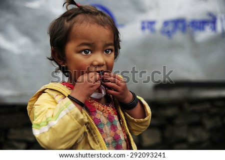 Baglung, Nepal. August 25-2010 Nepalese girl who lives in the path of the Annapurna, happy sucking candy