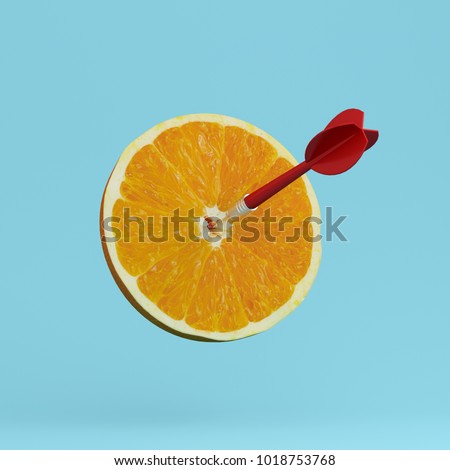 Orange fruit with circular target marked and red dart on pastel blue background. minimal idea food and fruit concept. An idea creative to produce work within an advertising marketing communications