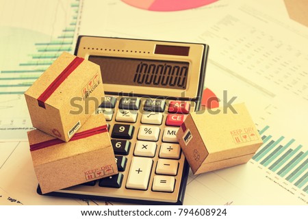 Closeup three cardboard boxes packing the product and calculator on technical chart of financial expansion. Idea of marketing planning and shipping costs, Control financial budget and service charge.