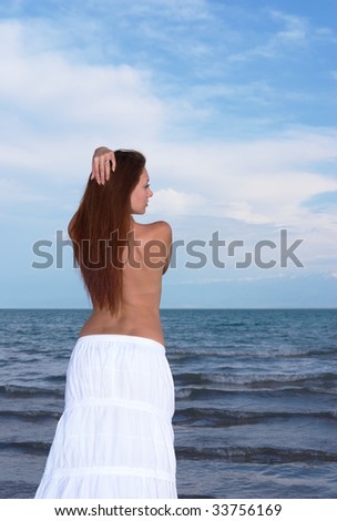 Lonely and sad young lady standing at the sea