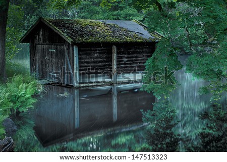 Old boat house in a forest lake