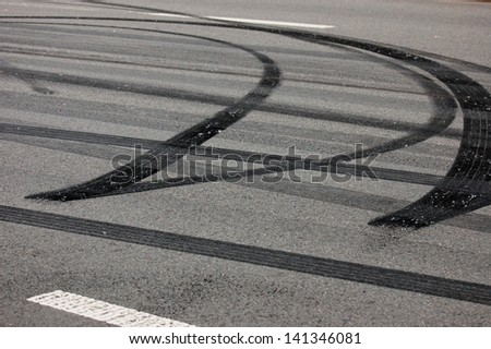 Black wheel spin prints on asphalt