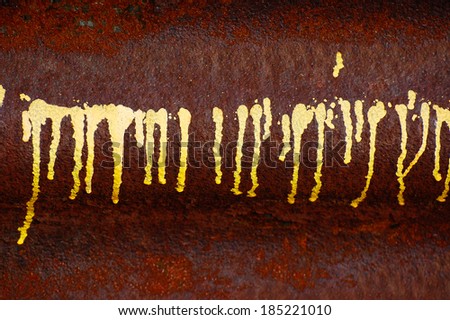 Yellow paint drips on rust background