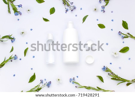 White organic pharmacy cosmetics flat lay with flowers and leaves. Clean beauty concept
