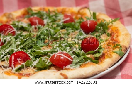 Vegetarian vegetable pizza with tomatoes and arugula on thin dough