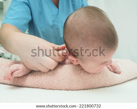 Baby massage doctor massage small caucasian crying baby boy back