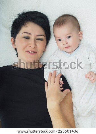 Happy caucasian family mom and son lying in bed at home