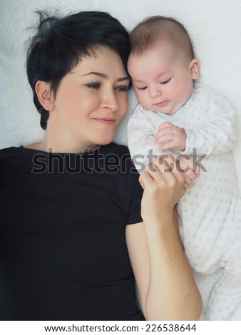 Happy caucasian family mom and son lying in bed at home