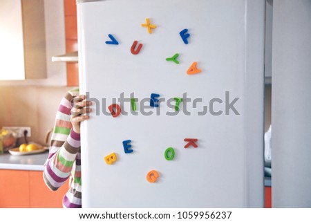 hungry woman looking in open fridge with Diet letters on door