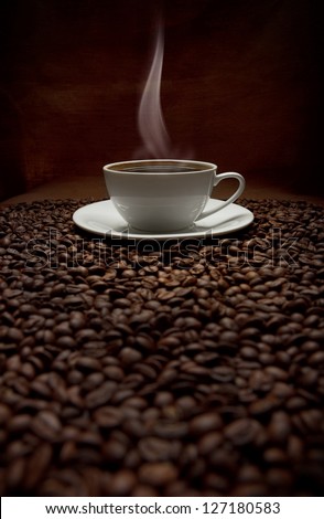 cup of steaming coffee with beans