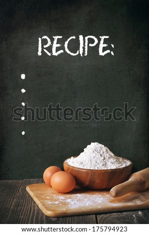 Flour and eggs on a blackboard background. space for recipe