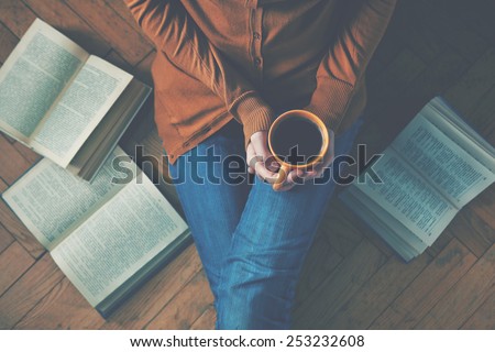 girl having a break with cup of fresh coffee after reading books or studying