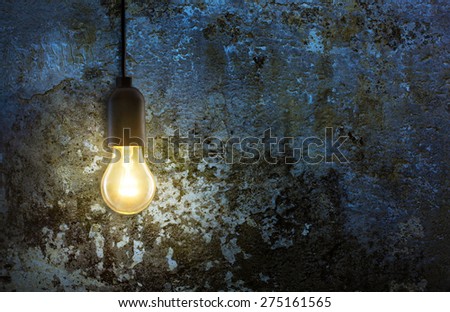 warm light bulb lamp on grunge wall background in the night