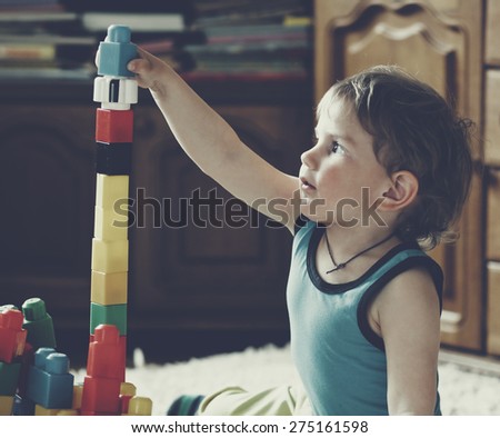 cute boy playing with toy blocks and bricks