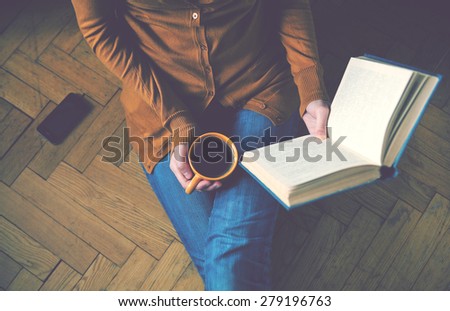 girl reading book and drinking fresh coffee