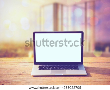 laptop with blank screen for copy on wooden boards table on office sunlight morning background