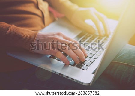 hands with laptop typing in sunlight