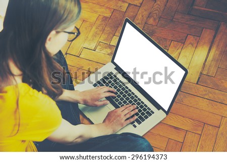 Girl using laptop and typing. Blank white screen for text or logo